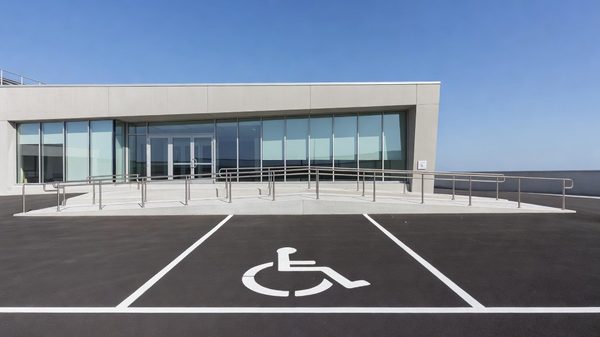 A parking pay station touchscreen terminal on a sidewalk beside a marked accessible parking bay