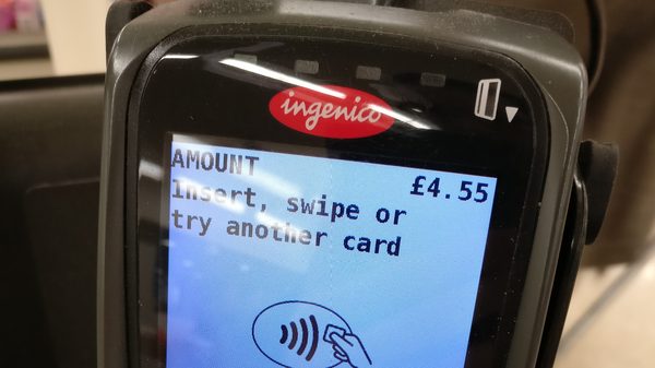 Unattended parking pay station with integrated EMV chip reader, contactless tap zone, and keypad
